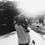 Black and white photo of a happy couple embracing on a sunny beach.